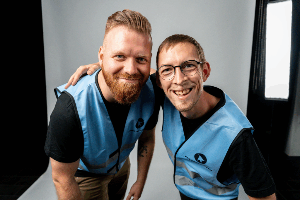 Videoproduktion Dresden Onlinewerbevideo zeigt ein Porträtfoto von zwei Männern Philipp Züschner und Stefan Kinzel, die freundlich in die Kamera schauen, einer der Männer umarmt den anderen, authentische Teamdarstellung für professionelle Videoproduktion Dresden und hochwertigeWerbevideo und Content Produktion